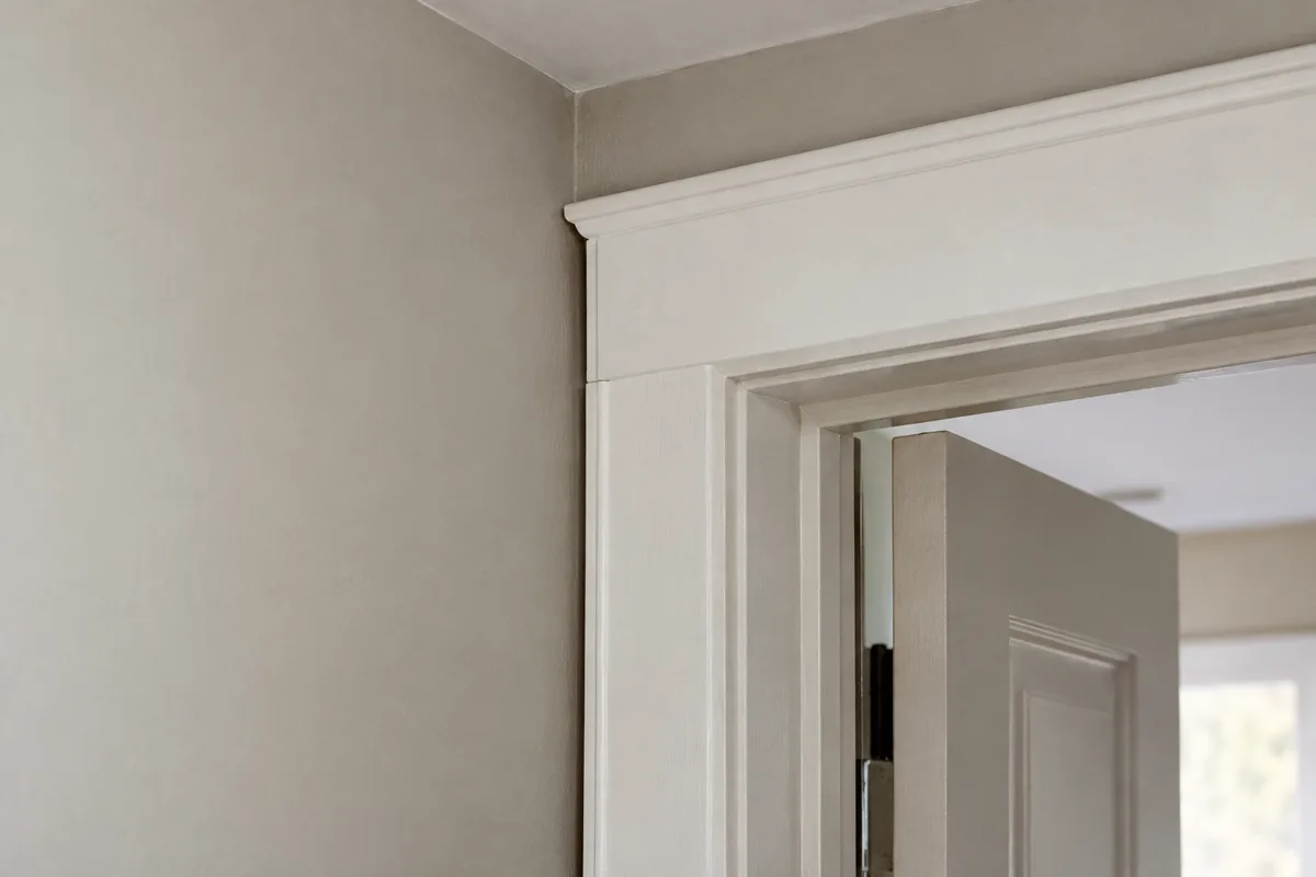 White door casing fitted close to an adjoining wall