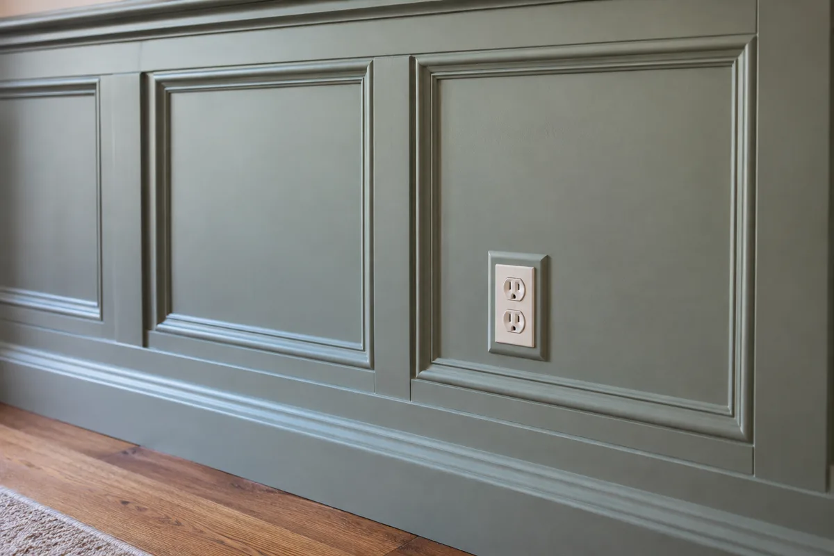 An outlet positioned inside a painted wall-molding frame