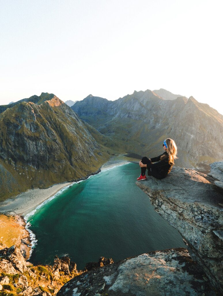 Woman sitting on a cliff enjoying nature view